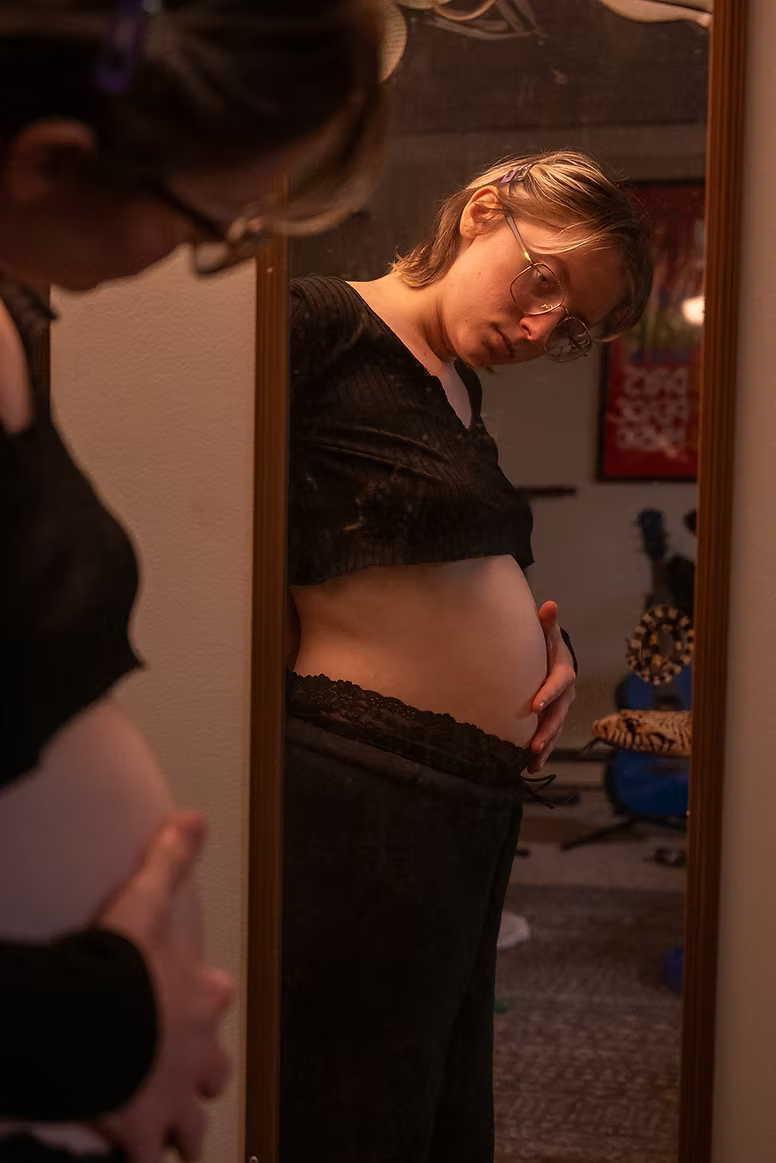 Willow holding his bloated stomach looking in the mirror.